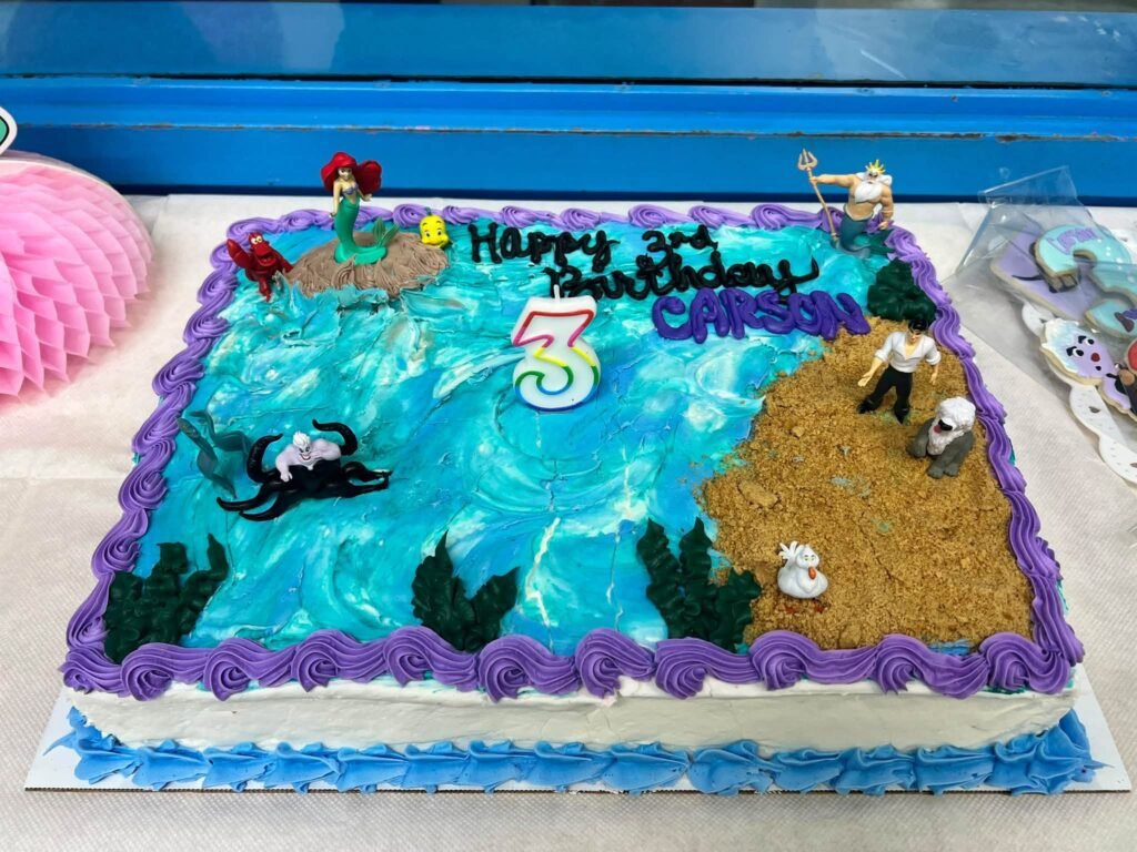 Ocean sheet cake with blue water, sand and small figures