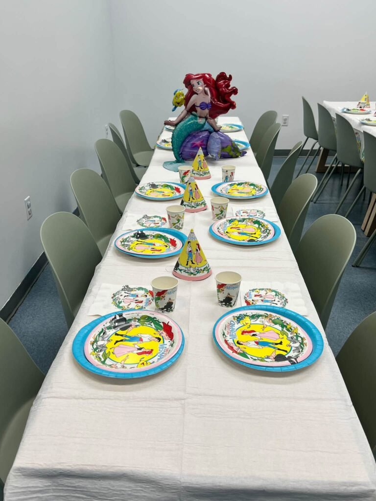 Long kids table with Little Mermaid plates and cups