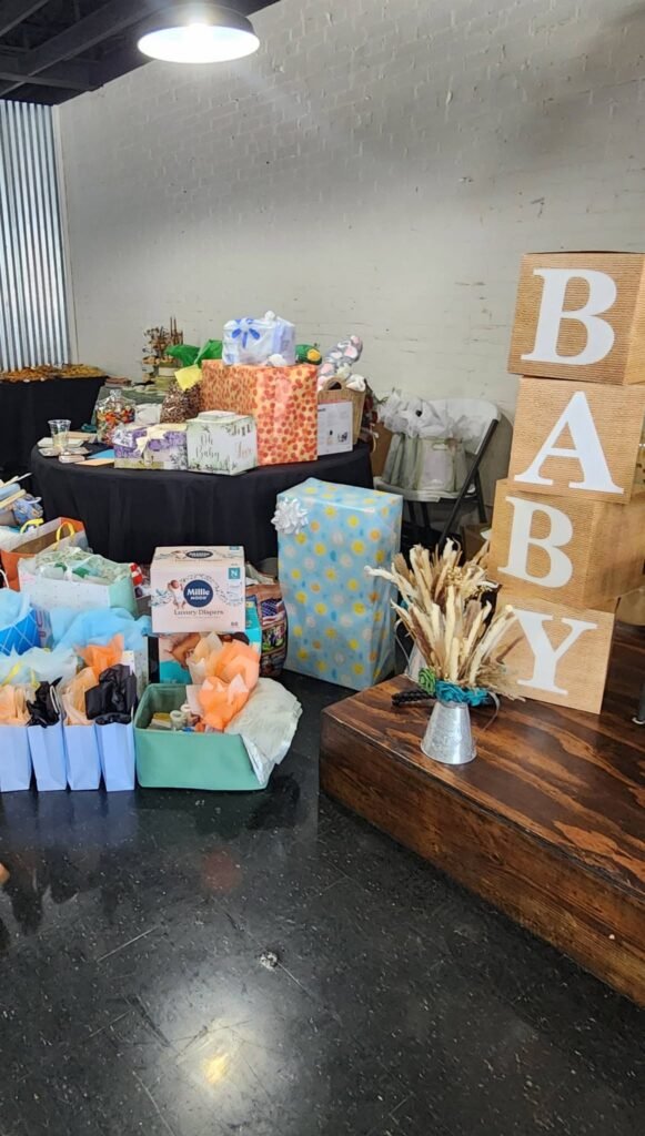 Baby shower gift table with wrapped gifts and BABY blocks