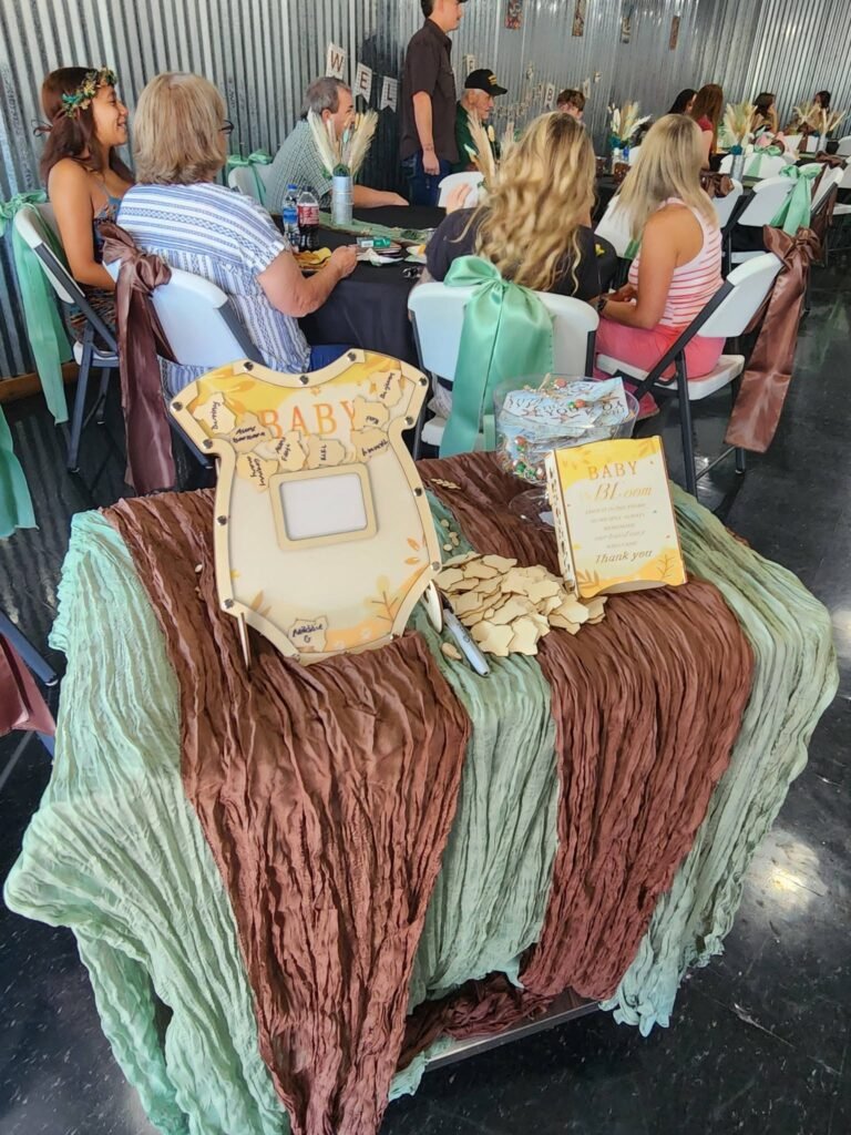 Baby shower tables with green velvet runners and onesie decor