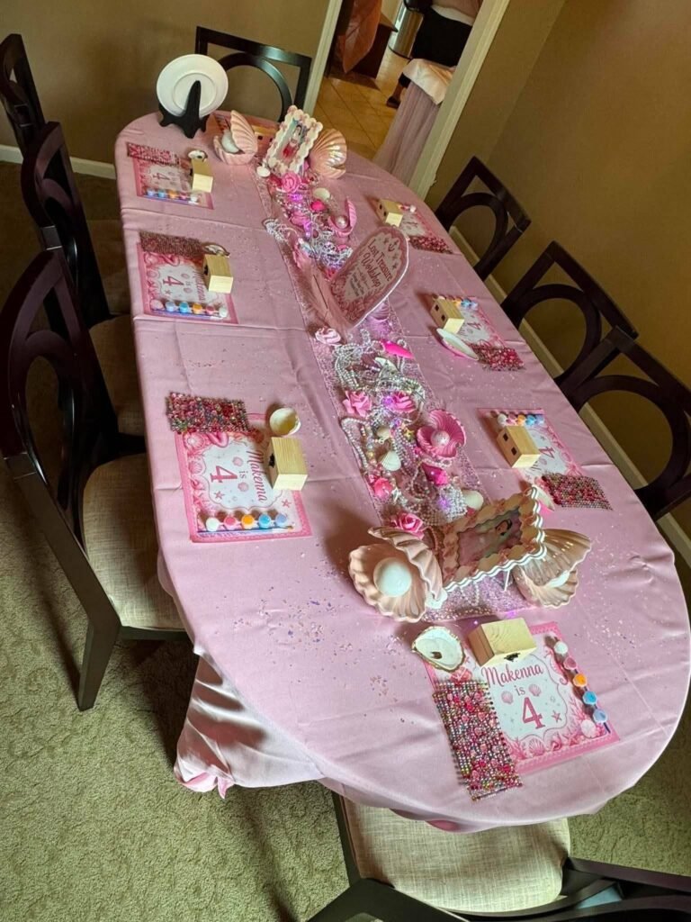 Long pink kids table with mermaid plates and favors