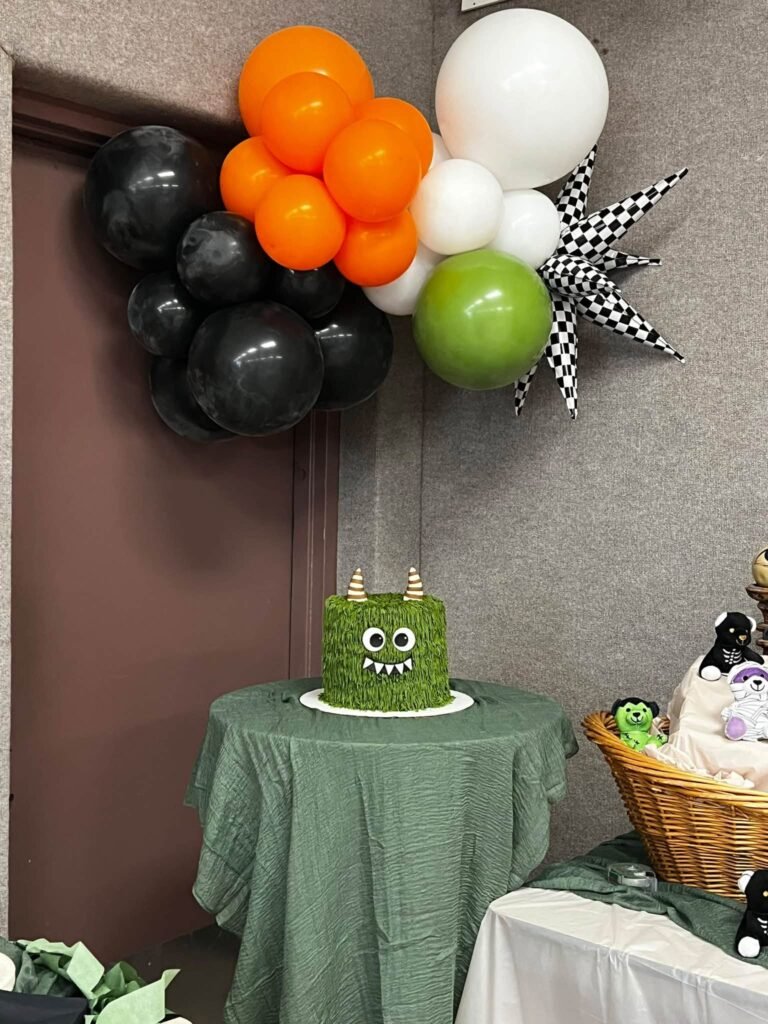 Balloon garland in orange, black and white with the monster cake