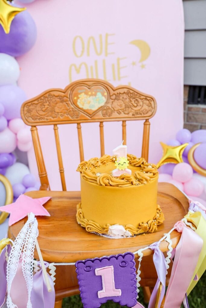 Wood high chair with a gold moon smash cake and a number 1 banner