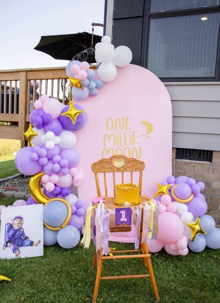 Pink One Little Moon arch with lavender and pink balloons on a deck