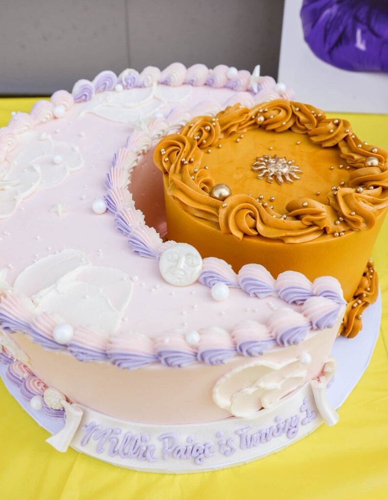 Round cake iced like a crescent moon with gold and lavender