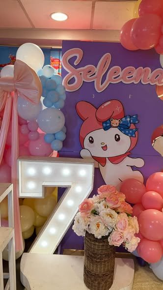 Close up of a light up number 7 with flowers in front of a My Melody backdrop