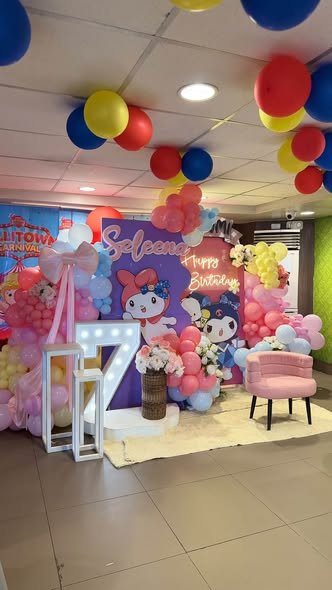 Wide view of a My Melody party corner with balloons, a backdrop and a pink chair