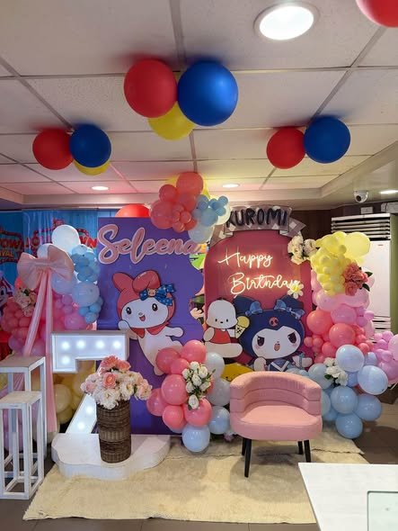 My Melody and Kuromi 7th birthday backdrop with a light up 7, balloon garland and a pink chair