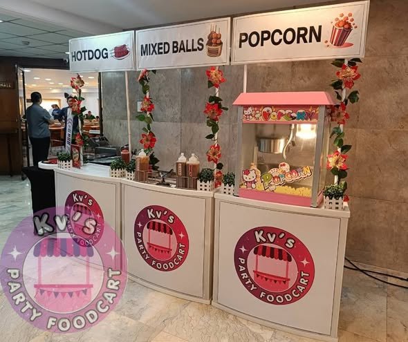 Hotdog, mixed balls and popcorn stations with flower garlands in a party hall