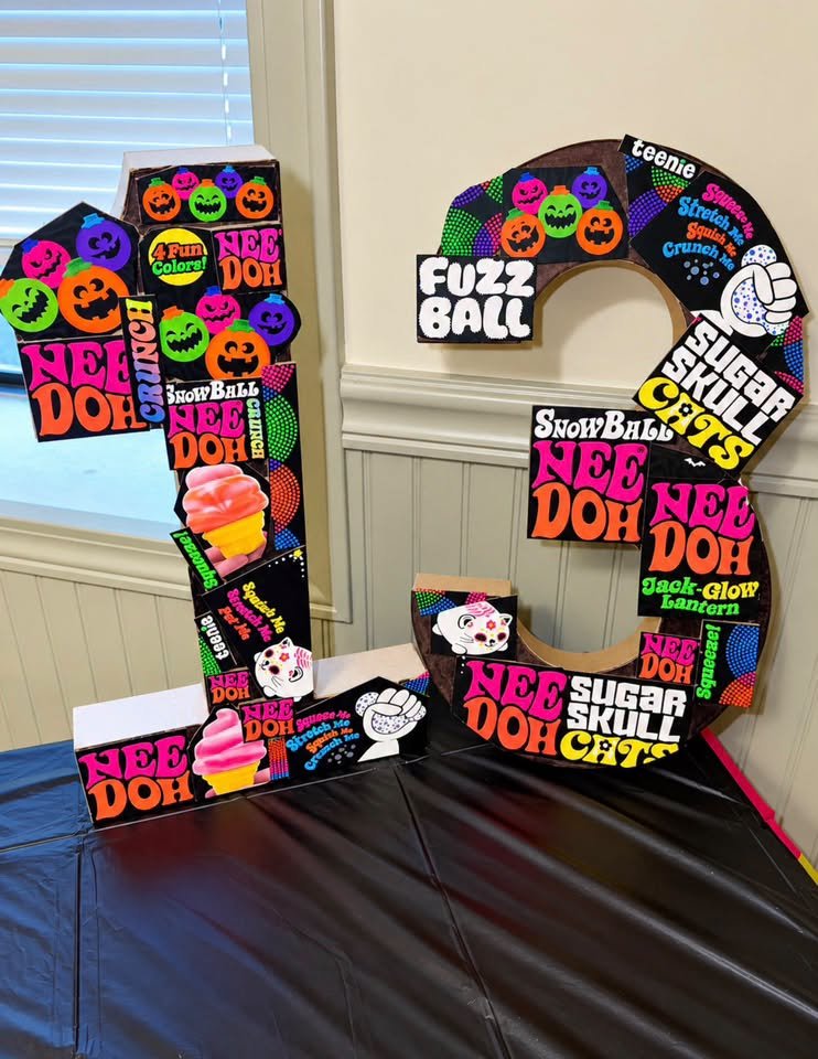 Large number 13 covered with Nee Doh stickers and pictures on the party table