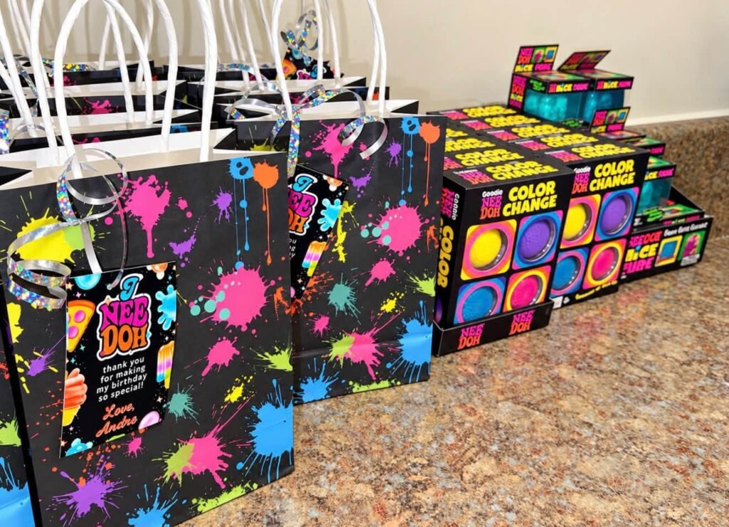 Paint splatter goodie bags with Nee Doh tags and toy boxes