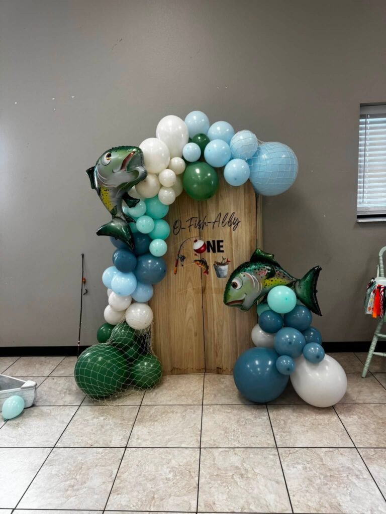 Fish balloon garland in blue, teal, green and white around a wood door backdrop