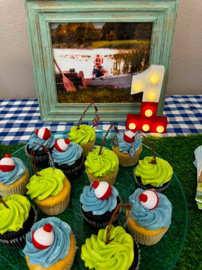 Bobber cupcakes with green and blue frosting next to a fish number 1 sign
