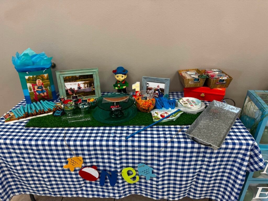Blue gingham table with photos, a bobber decor and fishing toys