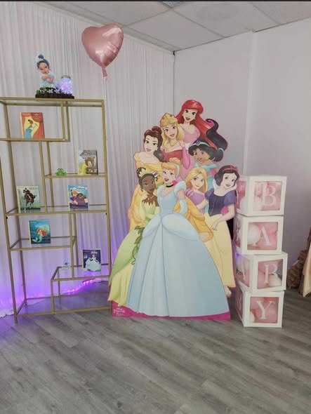 Princess cutouts next to a gold shelf and BABY blocks at a baby shower