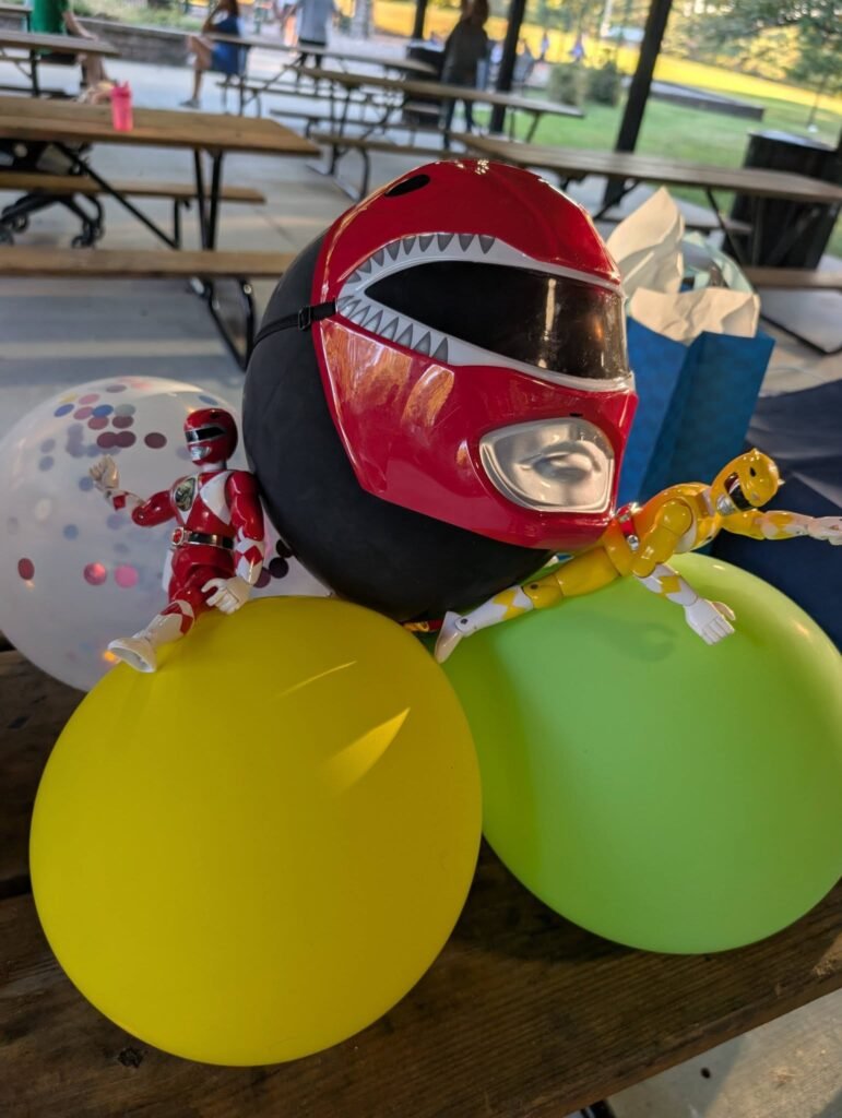 Red Power Ranger helmet with yellow and green balloons