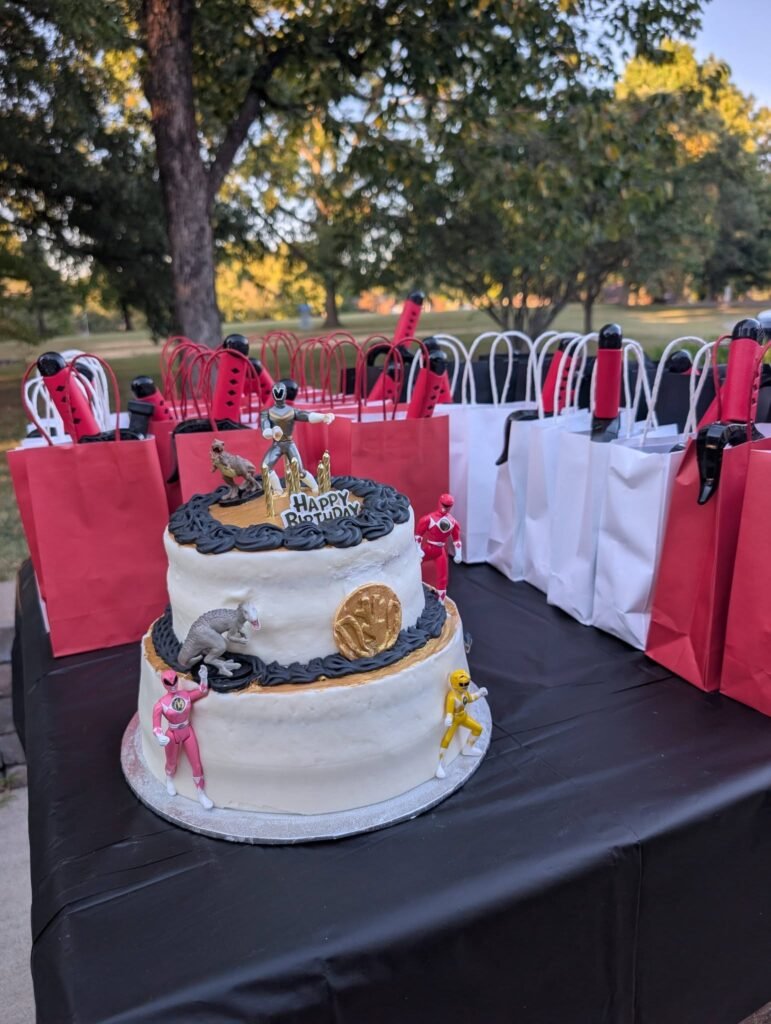 Power Rangers cake on a picnic table with gift bags