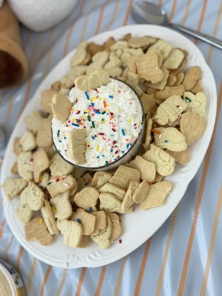 Plate of animal crackers around a bowl of sprinkle dip