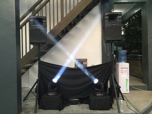 Moving stage lights shining from a black stage with speakers