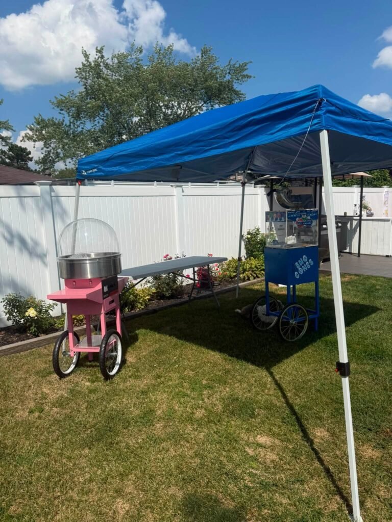 Cotton candy machine under a blue canopy in a backyard