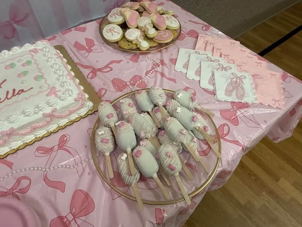 Pink chocolate dipped treats and bow cookies on gold trays