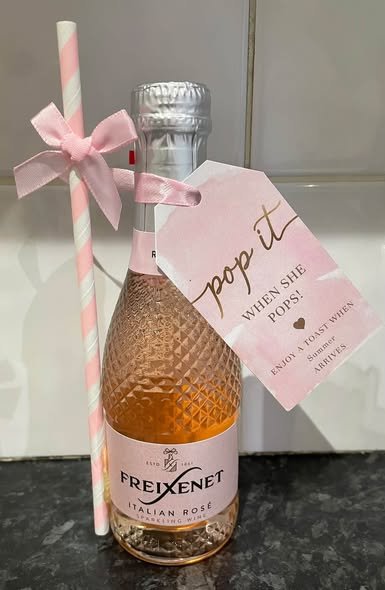 Mini bubbly bottle favor with a pink straw and a pop it when she pops tag