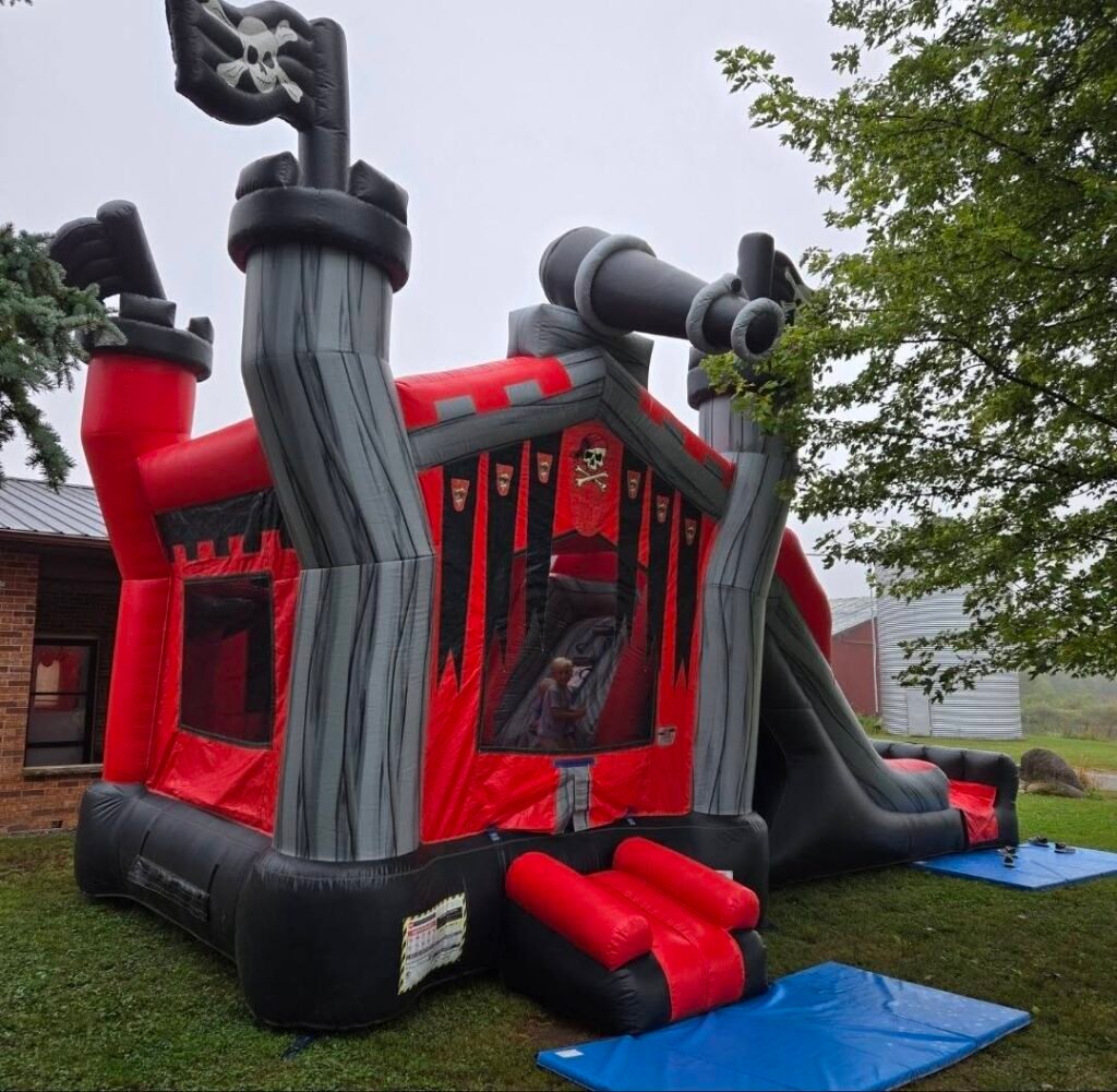 Red and black pirate ship bounce house on grass