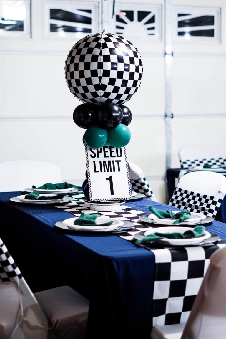 Checkered table runner with a checkered balloon centerpiece and a speed limit 1 sign