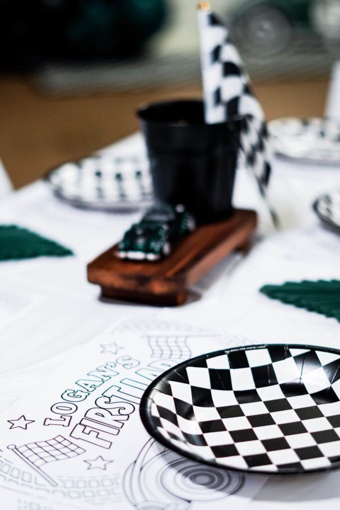 Toy race car on a wood stand with a black bucket and checkered flag centerpiece