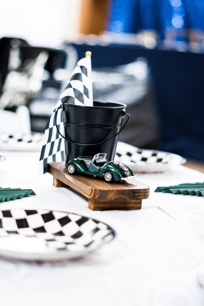 Close up of a green toy race car and checkered flag on a party table