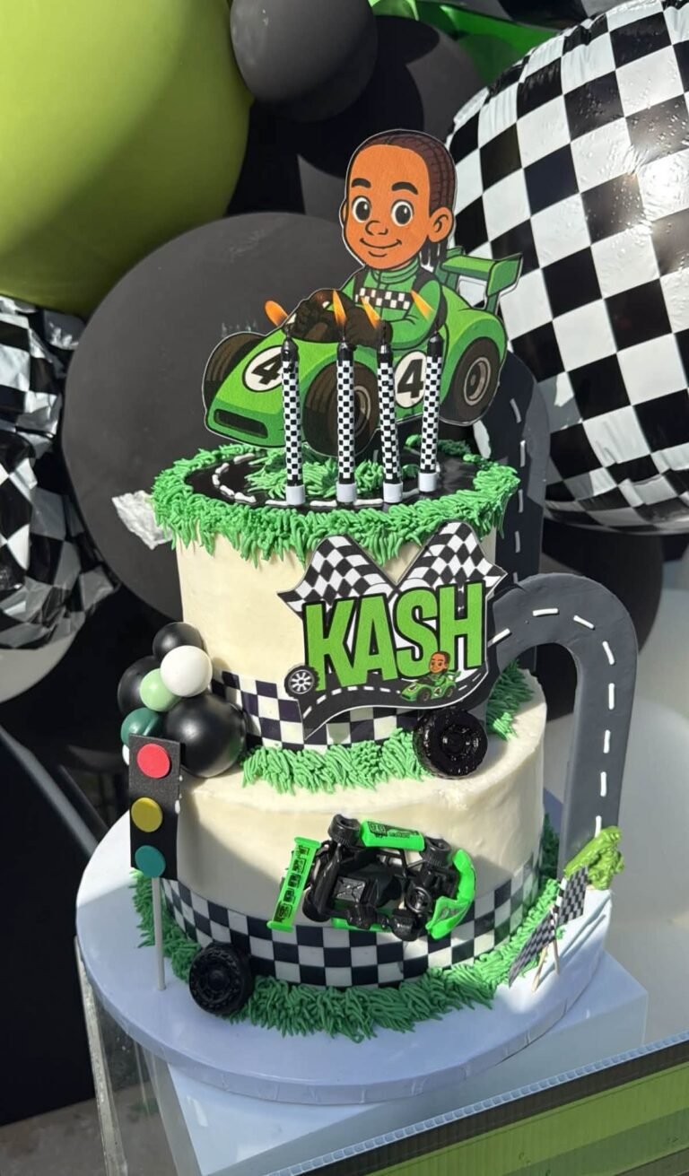 Green and black race car birthday cake with checkered flags and a topper