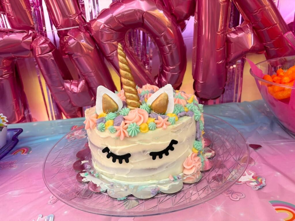 Sleeping unicorn cake with a gold horn and pastel mane