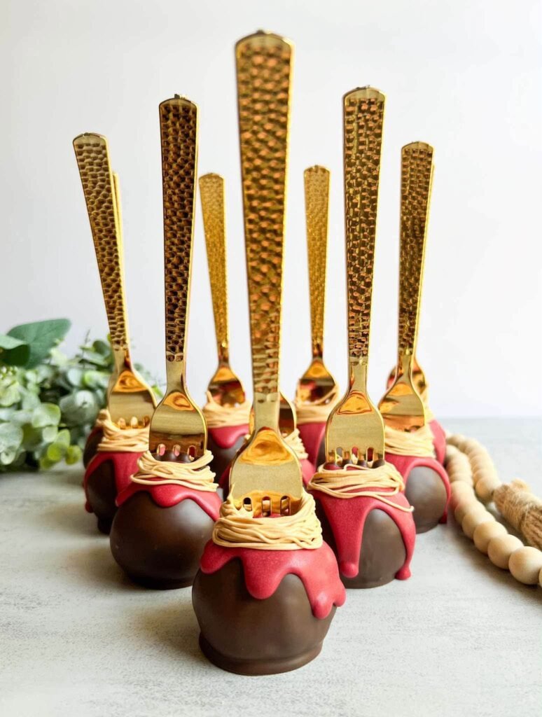 Chocolate cake pops with gold forks and red drips