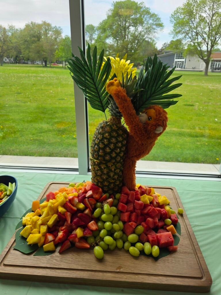 Pineapple palm tree fruit display with grapes, strawberries and melon