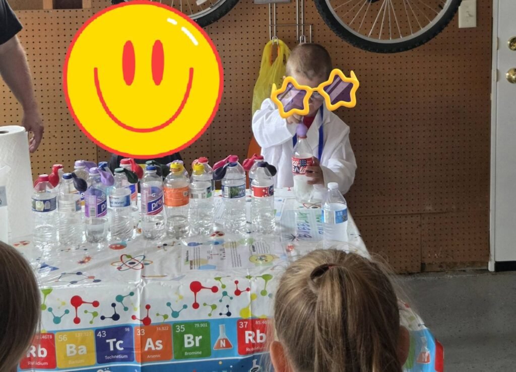 Water bottles on a periodic table cloth with a smiley balloon