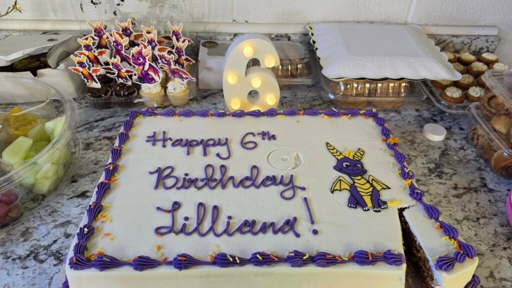 Spyro dragon 6th birthday sheet cake with purple trim and a number 6 marquee