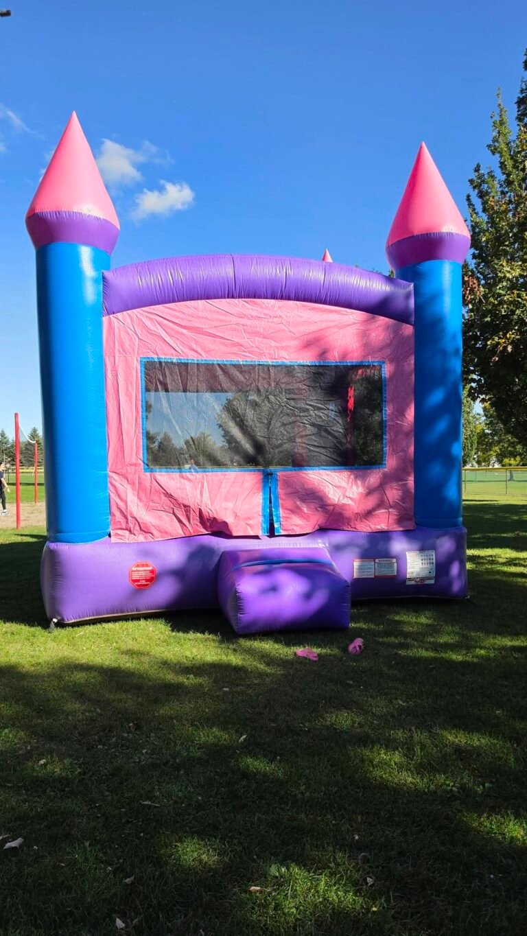 Pink and purple castle bounce house on the grass