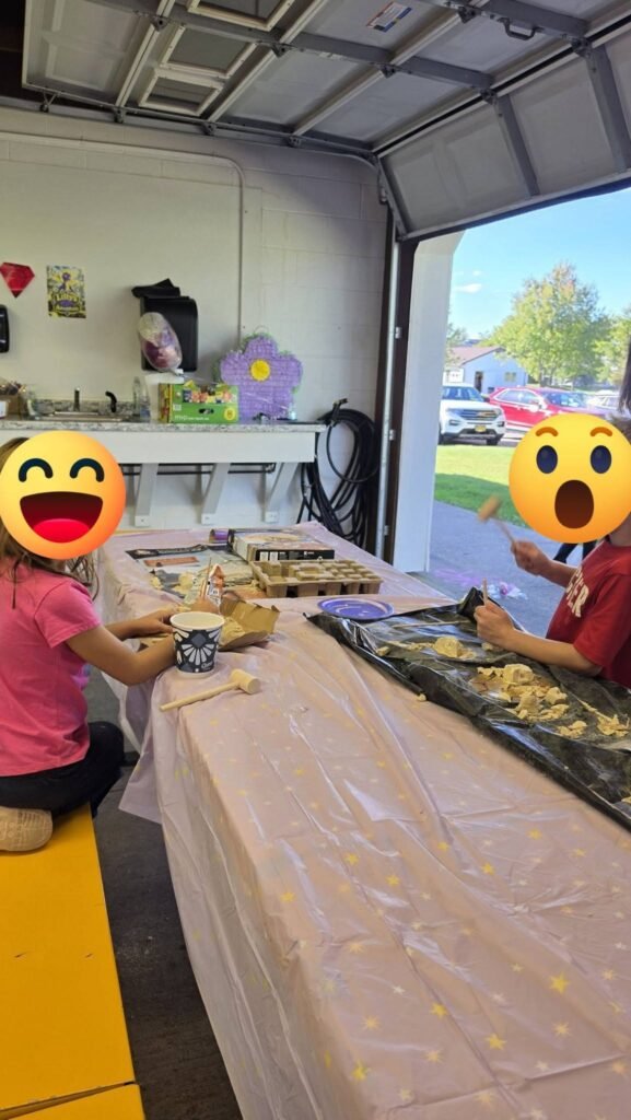 Kids eating at a long snack table in a garage party space