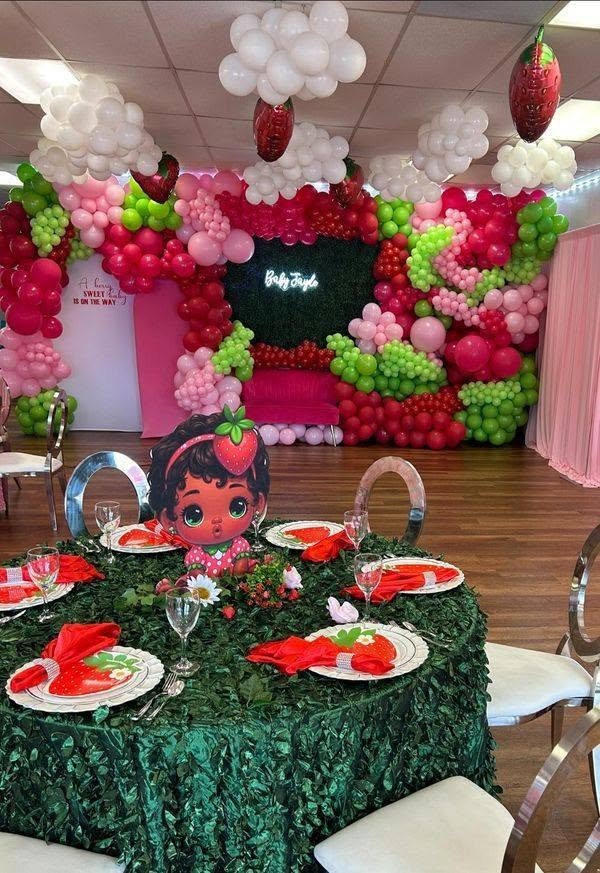 Strawberry birthday room with green sequin tables and strawberry plates