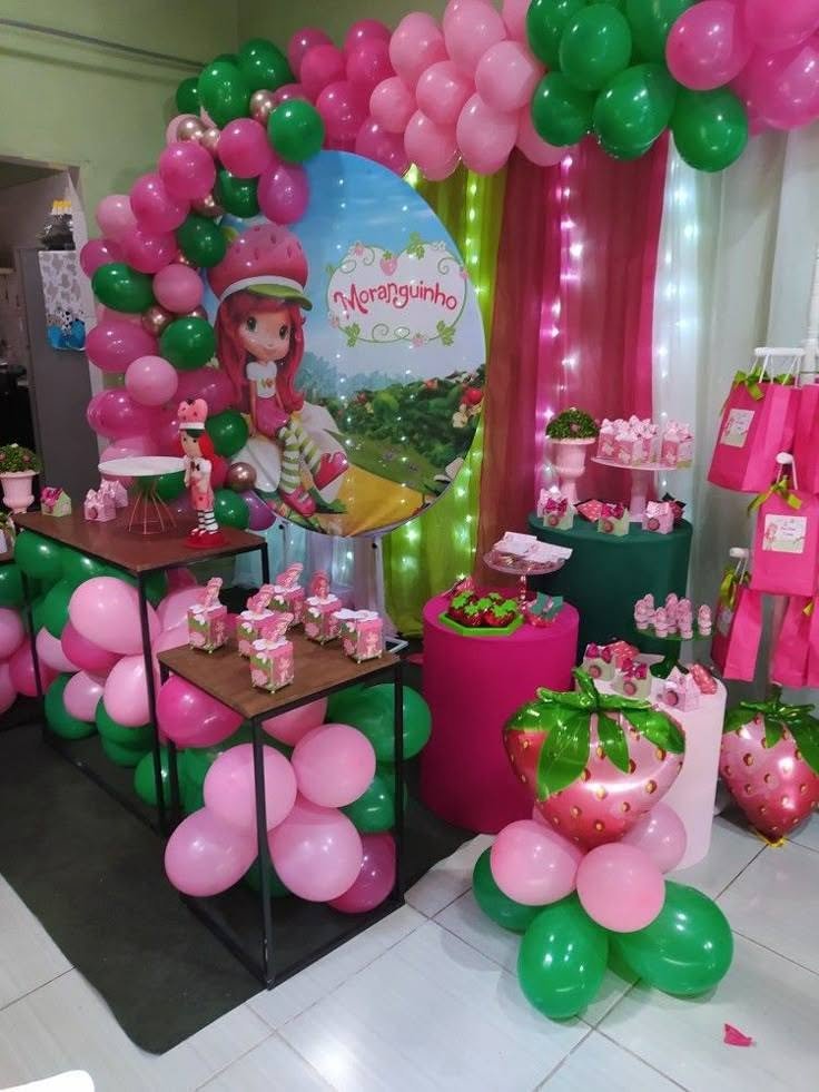 Strawberry Shortcake dessert table with a character backdrop and balloon arch