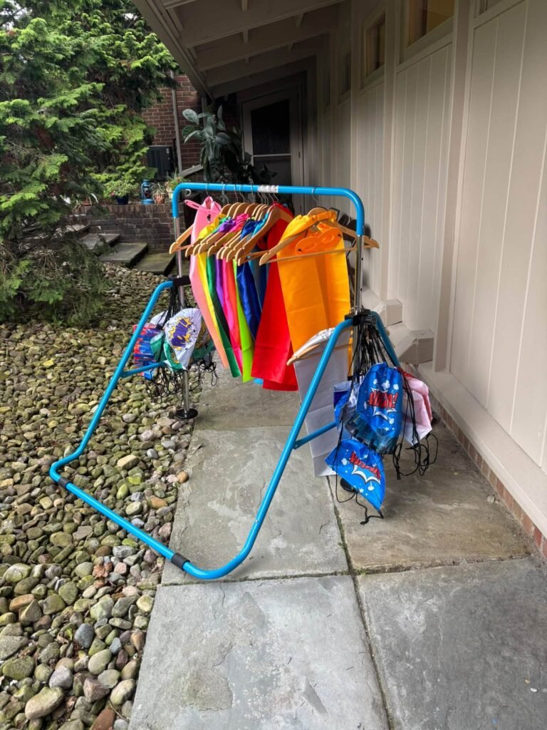 Rack of superhero capes for kids by the party door