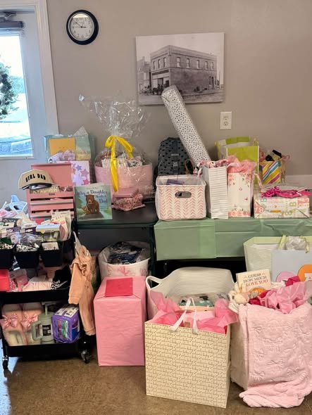 Baby shower gift corner with gift bags, a stroller and baby items