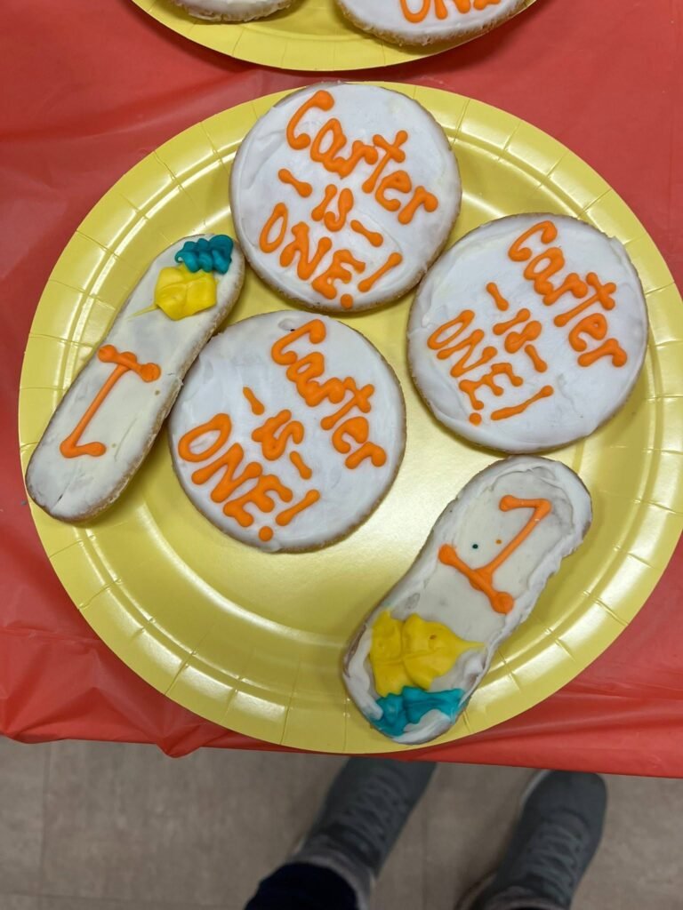 Cookies that say is one on a yellow plate