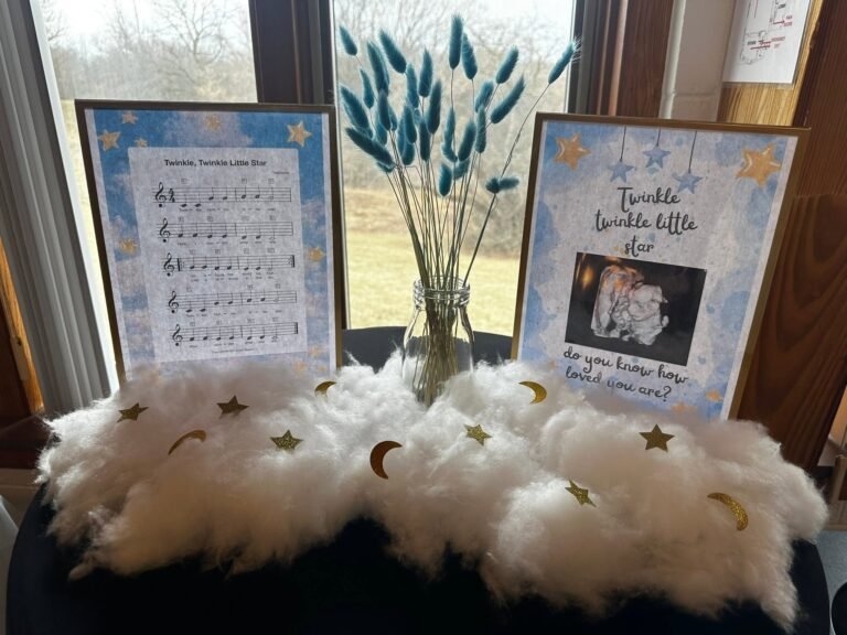 Framed lullaby sheet music and baby photo with pampas on fluffy white clouds