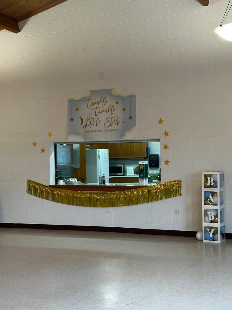 Kitchen window with a Twinkle Twinkle sign and gold fringe