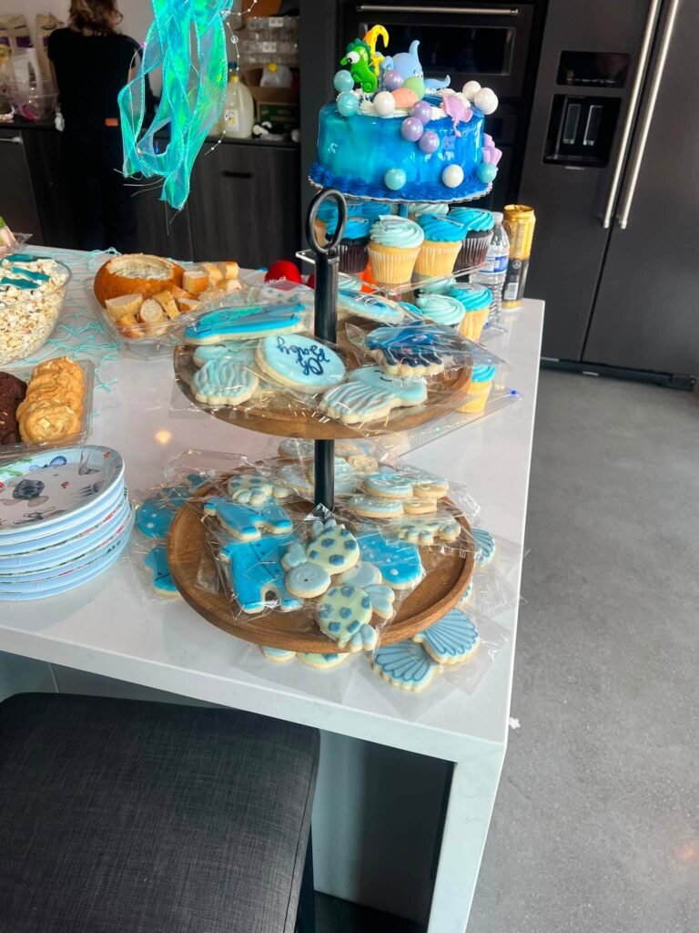 Tiered tray with sea cookies and a small blue cake on top