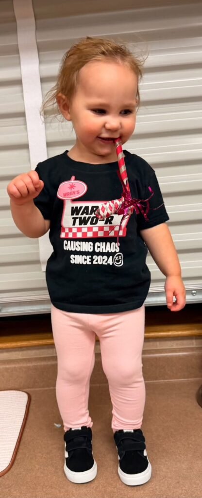 Toddler in a black Warped Two shirt and pink leggings