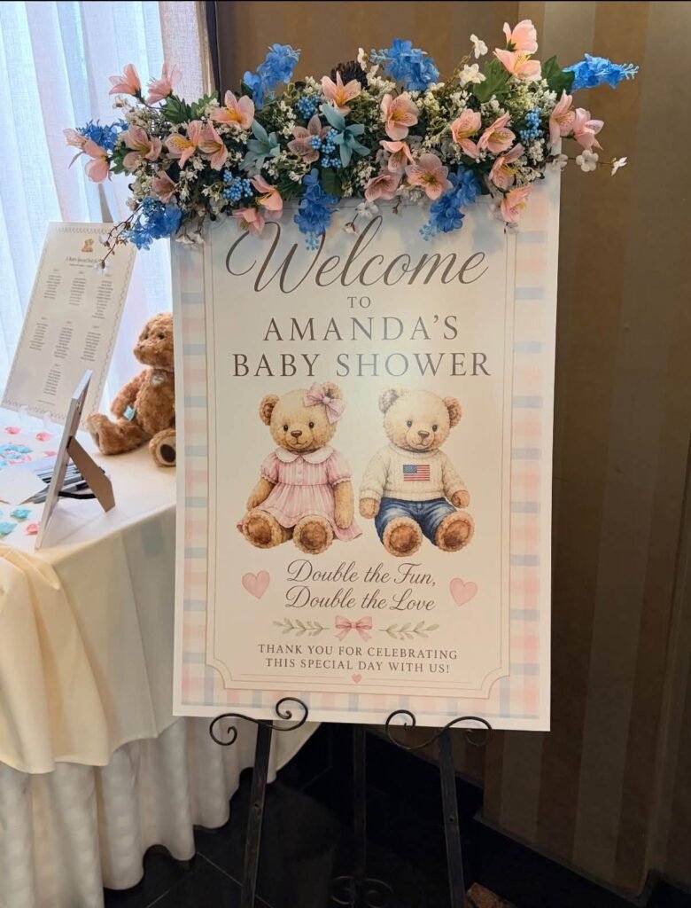 Welcome sign with teddy bears and pink and blue flowers on top