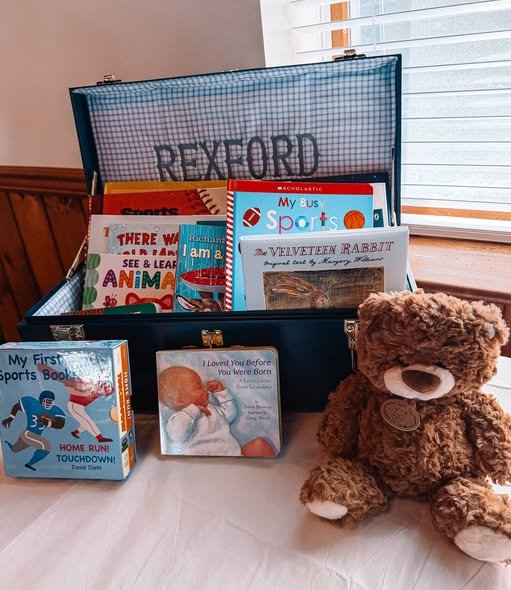 Vintage suitcase filled with baby books and a brown teddy bear