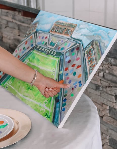 Guest painting a colorful canvas at a baby shower